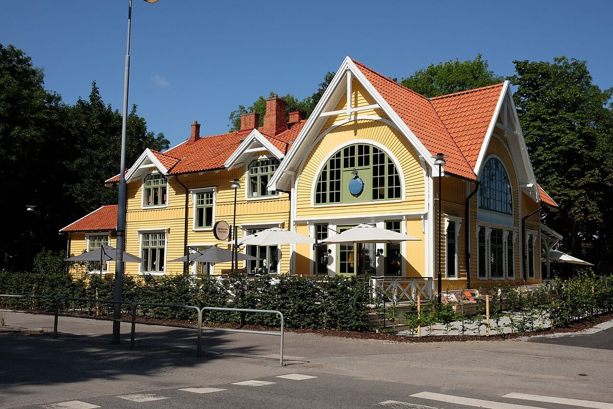The yellow historic Bjerreds Station building with outdoor seating